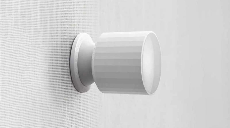 The Qingping Motion Sensor T with HomeKit over Thread, mounted on a vertical mousseline-like surface in light gray.