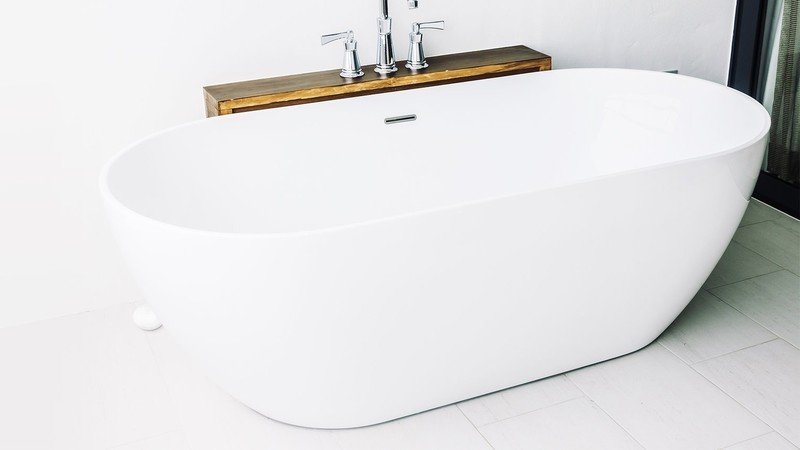 Fibaro flood sensor for HomeKit next to a bathtub